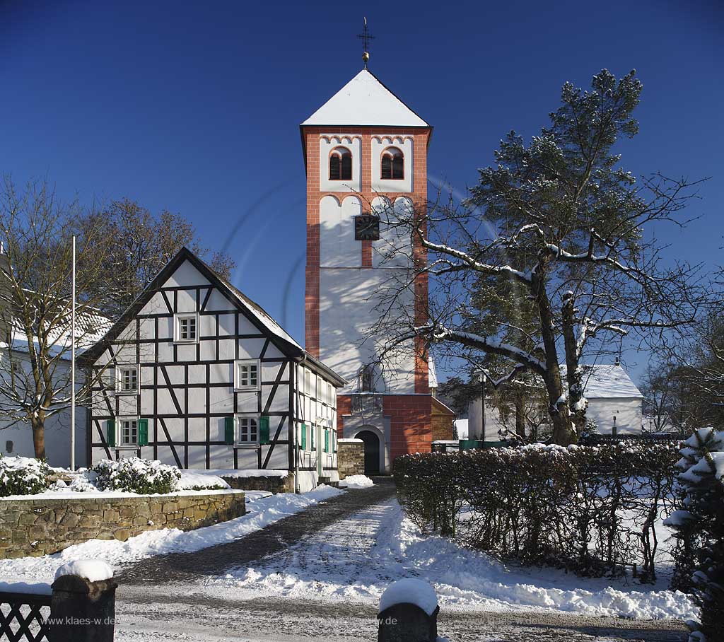 Odenthal Sankt Pankratius Pfarrkirche umgeben von Fachwerkhaeusern im Schnee; St. Pankratius church with half-timbered houses in the surrounding in snow.
