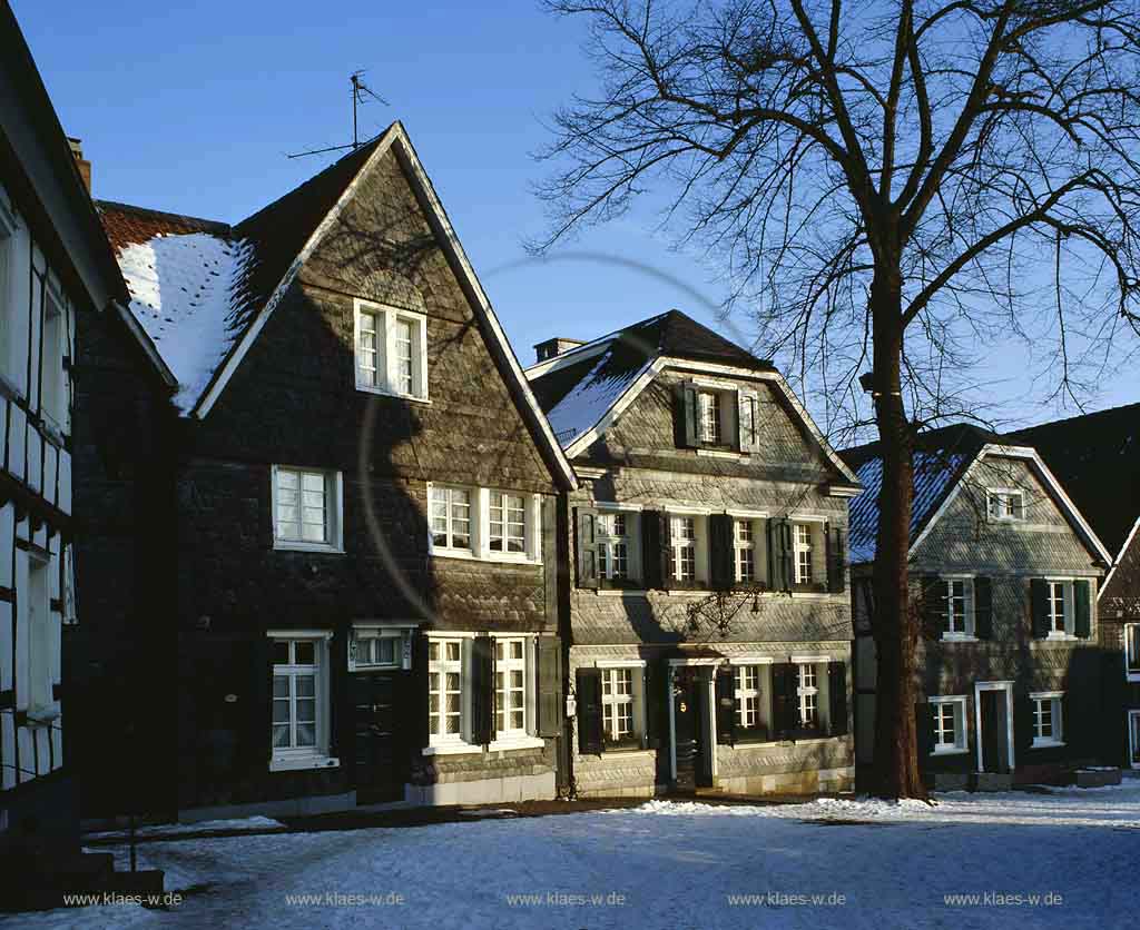 Wuelfrath, Wlfrath, Kreis Mettmann, Blick auf Kirchplatz mit Schiefer und Fachwerk Haeusern, Husern im Winter mit Schnee