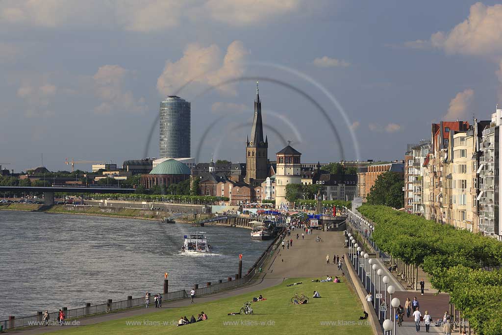 Blick aus suedlicher Richtung auf Rheinpromenade in Dsseldorf, Duesseldorf in Sommerstimmung mit Sicht auf Victoria Turm; Sankt Lambertus Kirchturm, Schlossturm mit Touristen, Besuchern