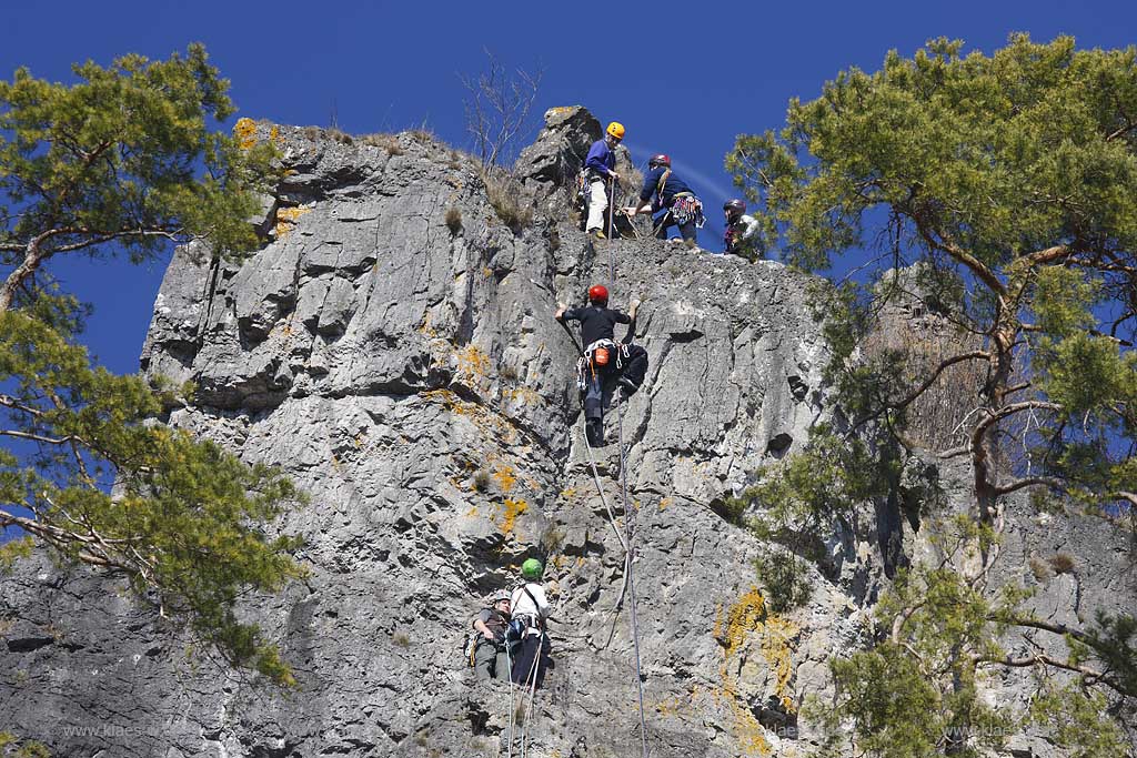 Gerolstein; Gerolsteiner Dolomiten mit dem Kletterfelsen Hstley UND Kletterern die die Felswand hinaufklettern; Rocks of Gerolstein named Dolomiten with climbing rock named Hustley and climbers