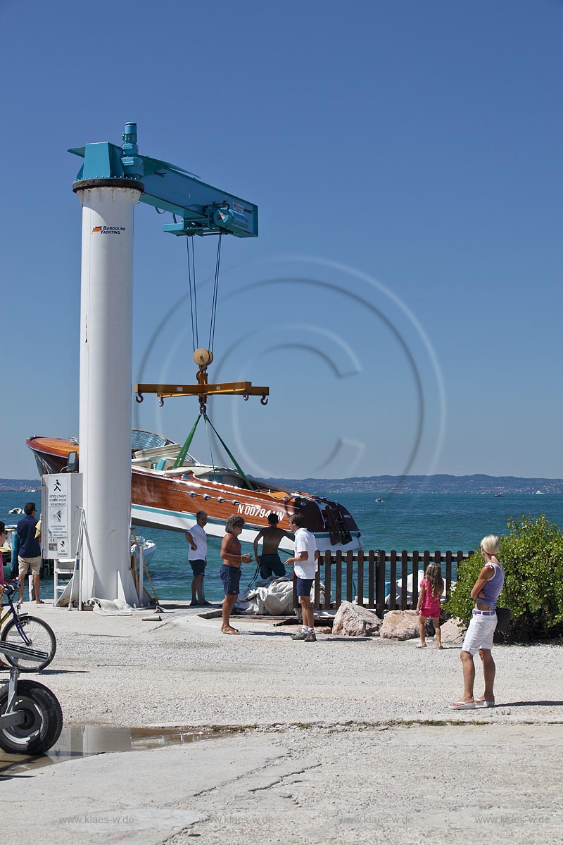 Bardoline Cisano, Bardolino Yachting Bootskran laesst Motorboot auf Gardasee zu Wasser;  Bardolino Yachting lounching a motormoat
