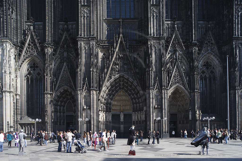 Koeln Domplatte mit Fussgaengern und Pantomimen die das Publikum animieren vor der Westfassade des Koelner Dom; Cologne pantomime in front of west side facade of the cologne dome
