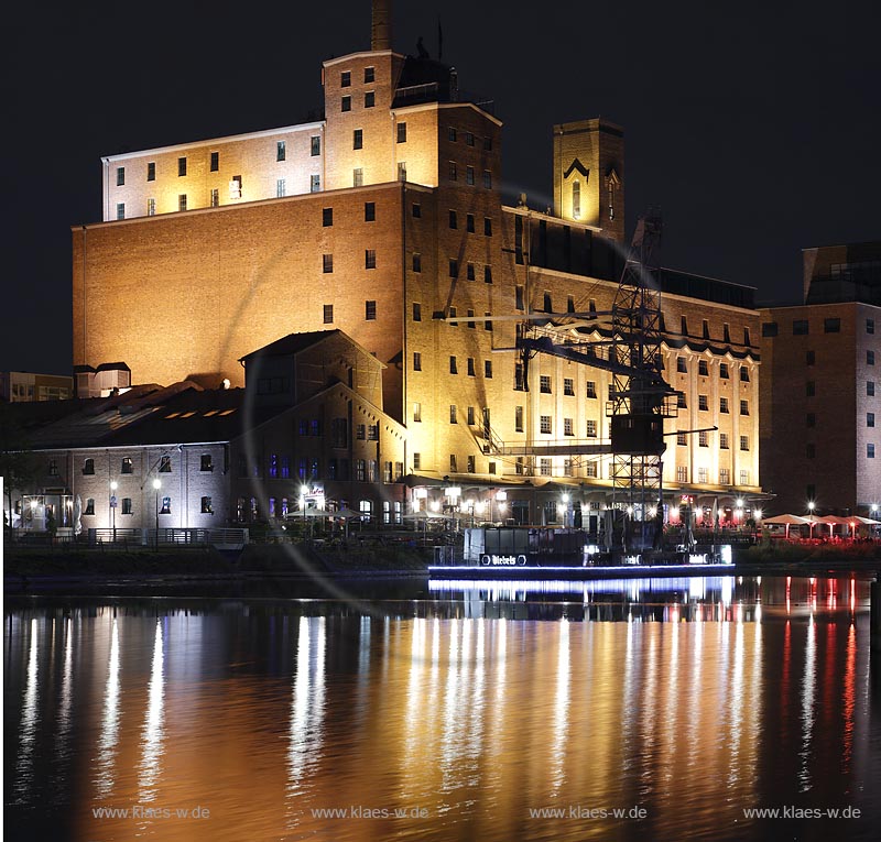 Duisburg, Innenhafen, Blick zur Wehrhahnmuehle mit Wasserspiegelung Nachtaufnahme bei Mondschein, die ehemalge "Cohen Muehle" wird heutzutage als Buero-, Museums- und Gastronomiekomplex genutzt; 