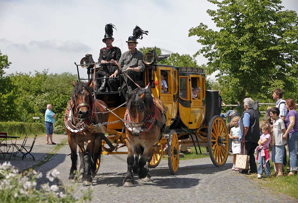 Lindlar Bergisches Freilichmuseum Lindlar fuer Oekologie und baeuerlich-handwerrkliche Kunst, nachgebaute historische Postkutsche, Nachbildung zweispaennig von 2 Kaltblut Pferden gezogen faehrt durch das Museum wahrend der Veranstaltung Jroen und Jedoen, Garten und Pflanzenmarkt mit Besuchern; Lindlar open-air museum with replication of a historical stagecoach