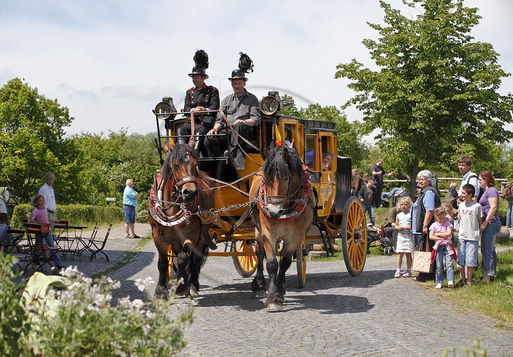 Lindlar Bergisches Freilichmuseum Lindlar fuer Oekologie und baeuerlich-handwerrkliche Kunst, nachgebaute historische Postkutsche, Nachbildung zweispaennig von 2 Kaltblut Pferden gezogen faehrt durch das Museum wahrend der Veranstaltung Jroen und Jedoen, Garten und Pflanzenmarkt mit Besuchern; Lindlar open-air museum with replication of a historical stagecoach