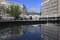 Blick auf den Hauptbahnhof in Düsseldorf, Duesseldorf-Innenstadt mit Sicht auf Skulpturen und Menschen und Spiegelbild vom Bahnhofsgebaeude im Teich