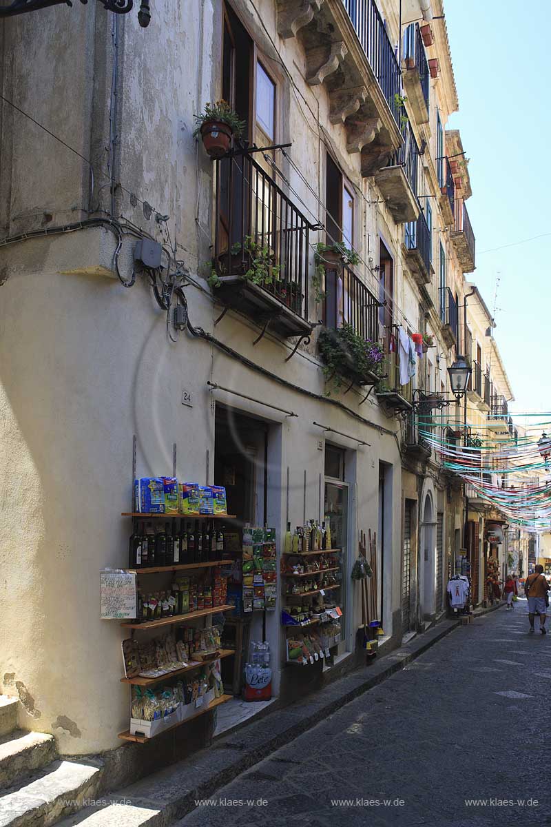 Blick in eine Altstadtgasse in der Stadt Pizzo in Kalabrien, Vibo Valentia, Italien mit Sicht auf Haeuserfassaden mit Balkonen und Geschaeften mit deren Auslagen vor den Haeusern