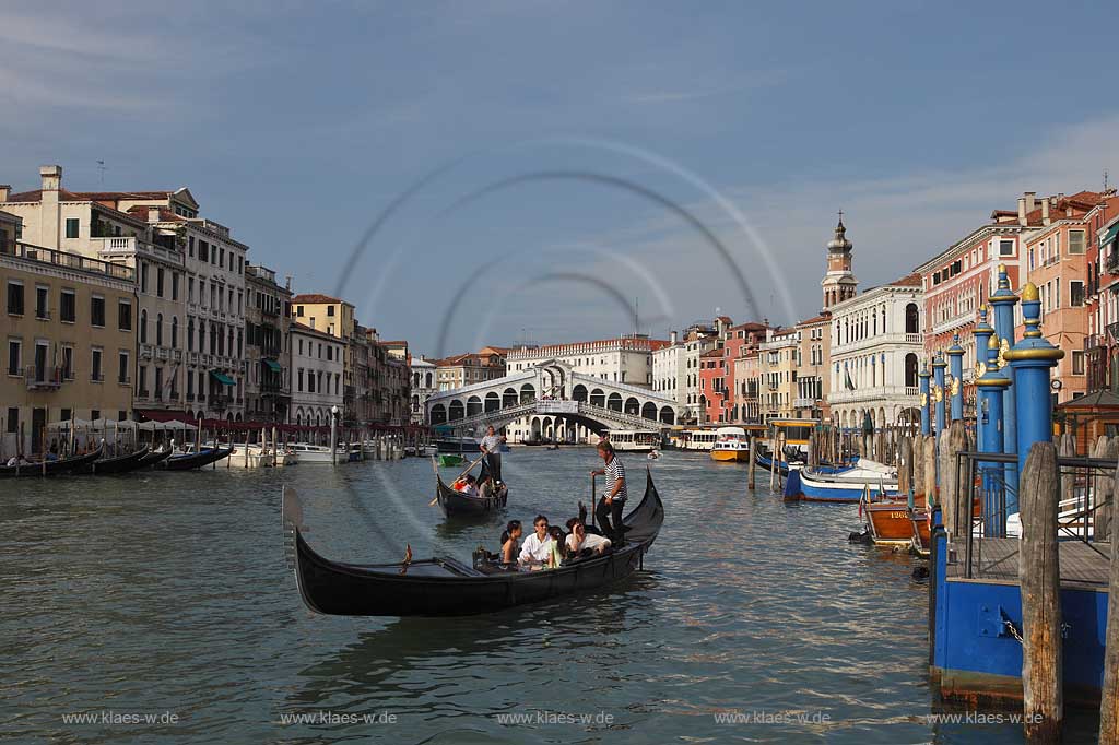 Venedig, Rialto, Blick von Riva del Carbon auf Kanal Grande mit der Rialtobruecke Ponte di Rialto, Kirchturm Campanile der Kirche Chiesea dei San Bartolomeo, Gondeln mit Gondoliere mit T Shirt quergestreift und mehreren Personen in Gondeln sitzend, eine Gondel Vordergund betonend ; Venice Rialto view from Riva del Carbon to Canal Grande with Rialto bridge, gondola and gondolier in raye transversalement t-shirt, several person sitting in gondola, one gondola near in front of picture, tower of church San Bartolomeo